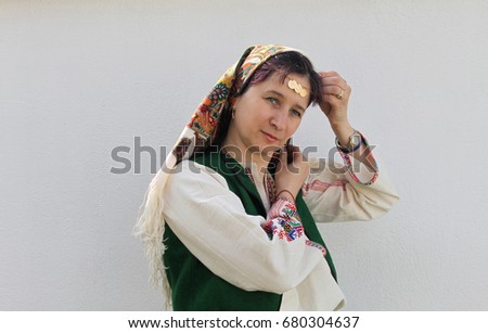 A beautiful woman dressed in Bulgarian folklore costume and a folklore headscarf