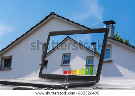 Laptop with picture of a house on the monitor. Concept Building design and architecture.