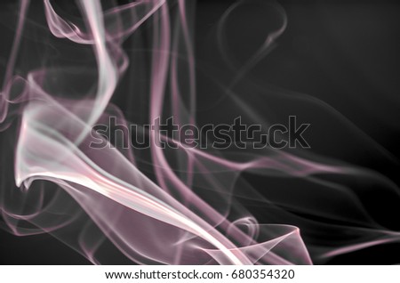 Thick, scenic clouds of smoke. From incense, or cigarettes, or cigars. Indoors. In the rays of sunshine on a dark background. Psychedelic mood. Close up. Colorful abstract background.