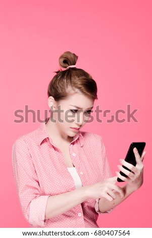 Retro asian business woman in colorful shirt look serious and touching a smartphone, beauty face, pink background.