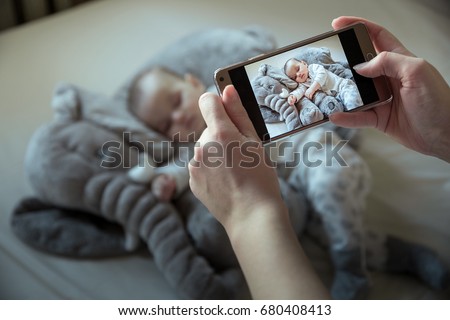 Mother shootin her sleeping newborn baby by smartphone