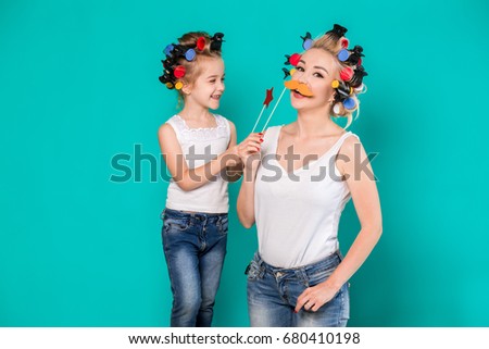 Funny family Mother and her child daughter girl with a paper accessories.
