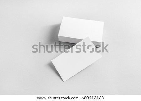 Photo of blank business cards with soft shadows on paper background. Mockup for branding identity. Studio shot.