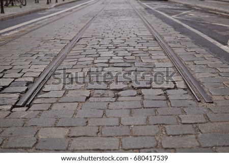 Detail of an end of rail tracks among cobbled road as a symbol of terminal station 