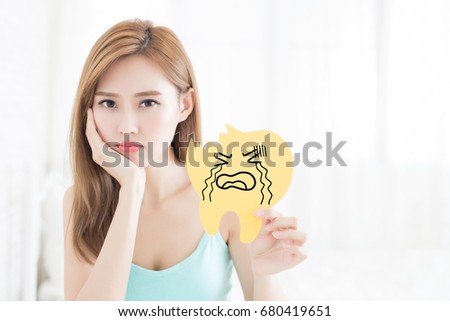 woman feel angry amd take decay tooth at home
