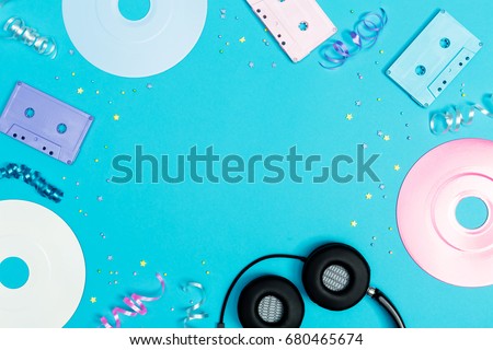 Music flat lay objects with vinyl records and cassette tapes on a blue background Royalty-Free Stock Photo #680465674