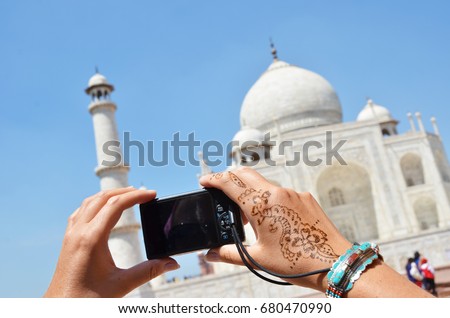 Camera in the hands pointing toTaj Mahal. Agra, India