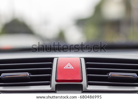 closeup car emergency light button with soft-focus and over light in the background