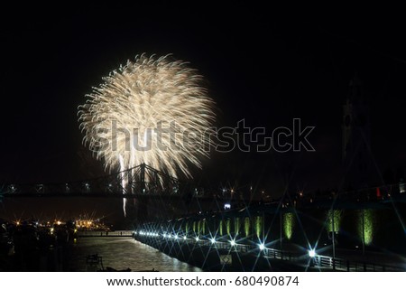 Festival de l'International des Feux Loto Québec.  Montreal fireworks festival. Colorful fireworks explode over bridge, reflection in water. Old port montreal.