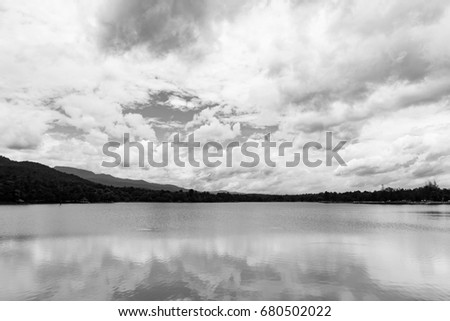 Black and white landscape picture of moutain, reservoir, and sky 