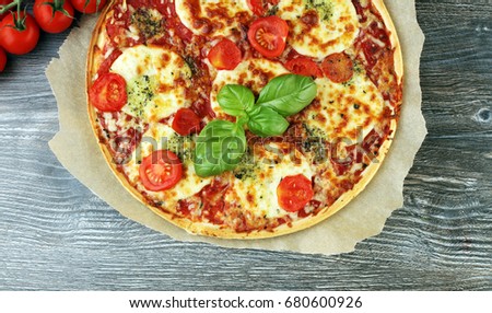 Hot true ITALIAN PIZZA with basil and cheese. TOP VIEW Tasty traditional pepperoni pizza on board on wooden table with decoration