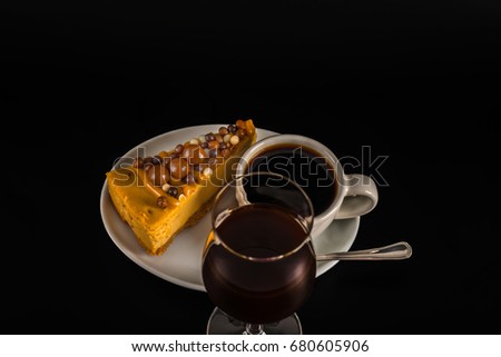 Aromatic black coffee in white cup with cheesecake on white saucer, coffee liqueur, brown sugar, teaspoon, black backround, tasty set