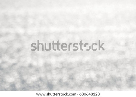 Blurry light on the water textured background. Sunny outdoors seascape bright surface