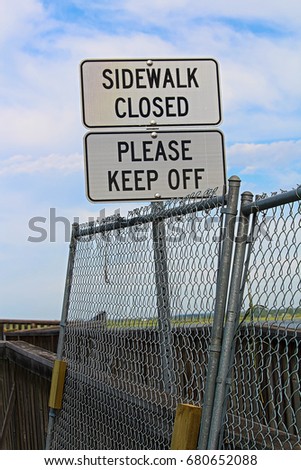 Sidewalk closed, please keep off signs closing a sidewalk