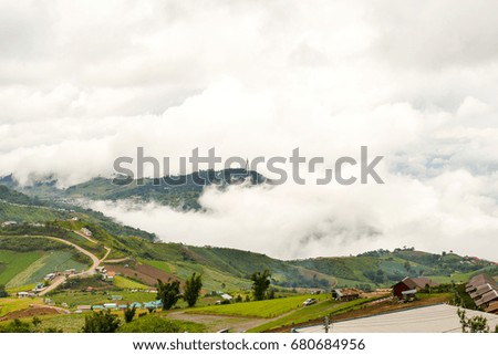 A picture of a mountain cloud with clouds floating in it.