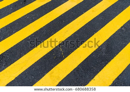 Asphalt Background with diagonal black and yellow warning stripes, asphalt and yellow hazard lines