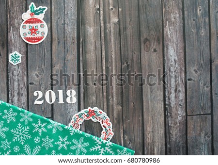 Green fabric with snowflakes, 2018 and christmas toys on a wooden background, christmas, new year, minimalistic design