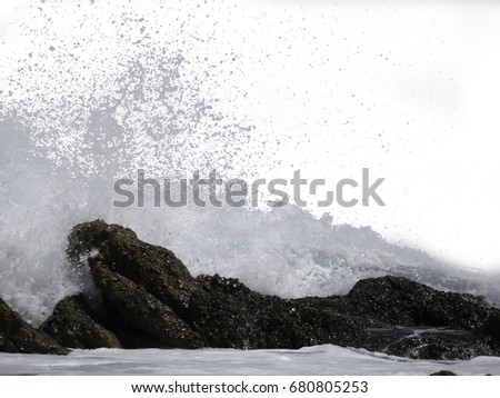 The sea wave crashing on the rock and make the splashing water and white air foam bubble. Isolated on white background with clipping path.