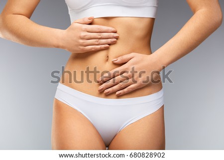 Pain In Stomach. Closeup Beautiful Woman With Slim Body In White Panties Feeling Abdominal Pain. Female Suffering From Stomach Ache, Holding Hands On Belly. Digestion, Health Issues. High Resolution