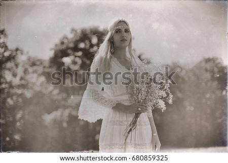 Vintage black and white photo of bride with white flowers in nature
