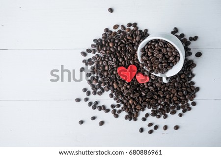 coffee bean in the cup with red heart on white wooden background