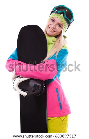 vertical picture, isolated on white, attractive  young caucasian girl in colorful ski suit and blue ski glasses hold black snowboard, hug snowboard, look at camera, smiling