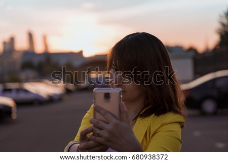 Woman making selfie with amazing sunset on the background