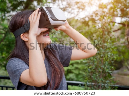 Beautiful Asian woman while playing or watching VR Box or virtual reality box or electronic 3D