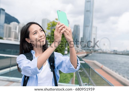 Woman taking photo on mobile phone in Hong Kong