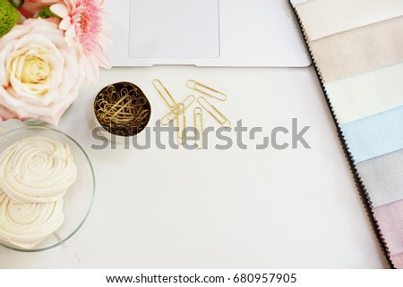 Fabric samples on the table. The designer workplace concept. Freelance fashion comfortable femininity workspace in flat lay style with flowers on marble background. Top view, bright, pink and gold