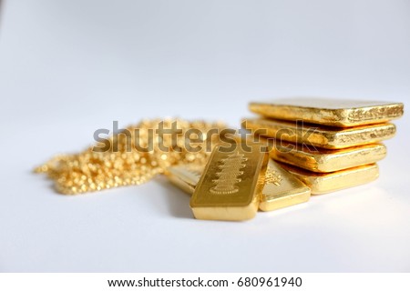 Gold jewelry and gold bullion on white background