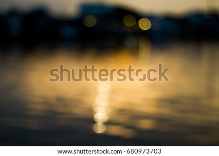 Abstract beautiful yellow bokey in the evening on river and city background