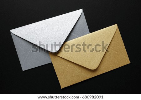 silver and gold envelopes on black background