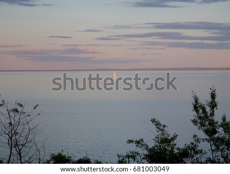 Lone sailboat on Lake Superior at sunset Royalty-Free Stock Photo #681003049