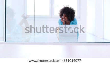 beautiful young african american women using laptop computer on the floor of her luxury home