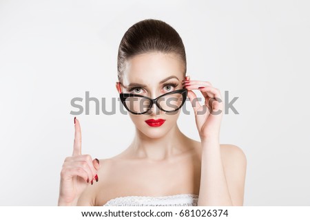 Attention listen to me. Close up portrait young woman wagging her finger holding glasses skeptically isolated white grey wall background. Negative human emotion face expression body language attitude Royalty-Free Stock Photo #681026374