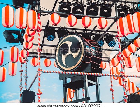 The stage of the Yagura with a big japanese taiko drum Odaiko with hidari-mitsudomoe symbol. Paper red-white lanterns Chochin Scenery for the holiday Obon when people dance of Bon Odori