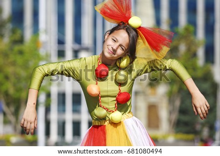 Funny clown in comical concept. Actor shows pantomime against the cityscape.