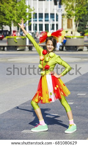 Funny clown in comical concept. Actor shows pantomime against the cityscape.