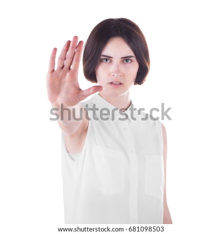 Close-up of an angry female is making stop gesture, isolated on a white background. A serious young brunette woman with stop sign. Business woman in elegant clothes making stop sign.