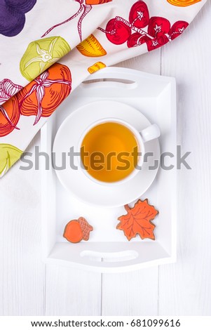 Autumn composition. Herbal tea and autumn gingerbread in the form of maple leaf and acorn on a white background. Top view