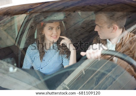 Beautiful female mechanic with a handsome man in the car