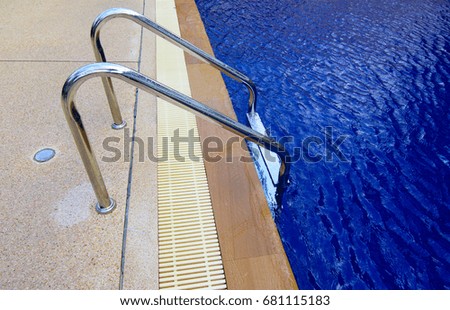 Soft focused picture of stainless steel Stairs down to the blue water in the pool
