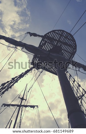 A crow's nest on a pirate ship. Galleon masts. Vintage colors. Retro sky