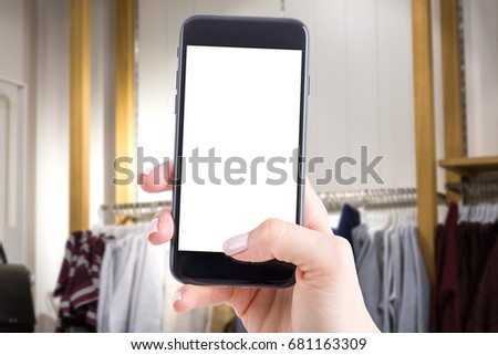 Smartphone with insulated screen and copy space in the background of the shop interior. Concept of online shopping, search promotion with your cellphone.