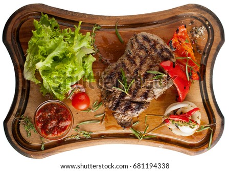 Juicy steak fillet mignon made from marbled beef with baked vegetables on a wooden board. Isolated