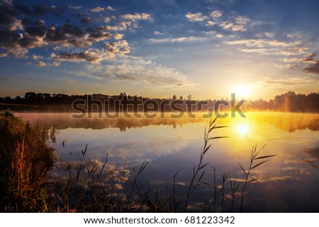 beautiful background of nature. wonderful misty landscape. amazing foggy morning, colorful sky reflected in the water of tranquil lake. picturesque dramatic scene.