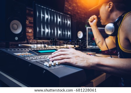 asian popular DJ working in radio broadcasting studio or music producer working in recording studio