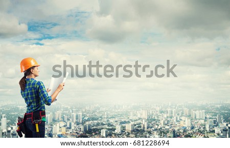 Engineer woman with blueprint on modern city landscape