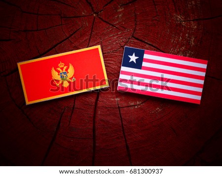 Montenegrin flag with Liberian flag on a tree stump isolated